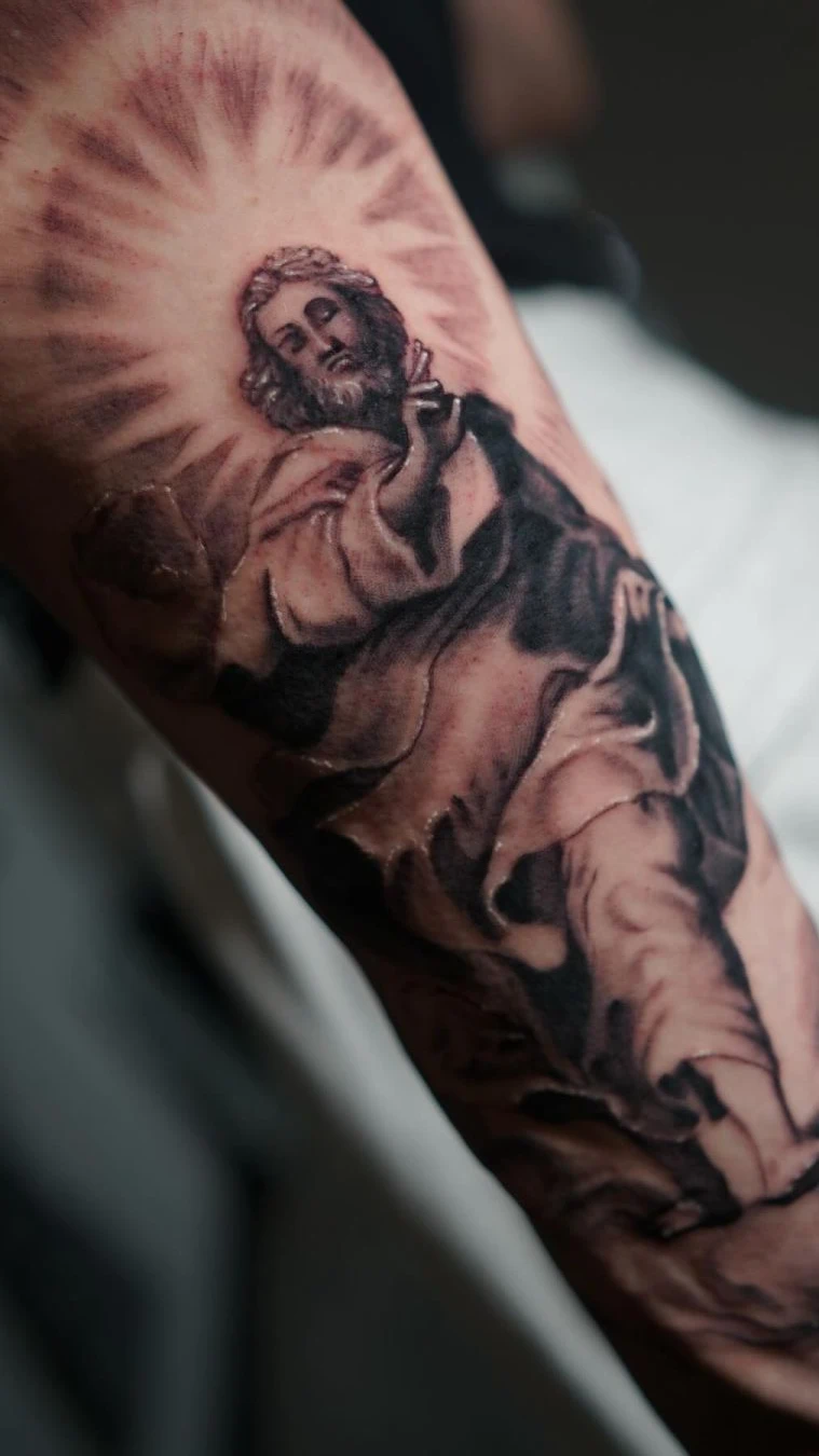 Jesus black and gray forearm tattoo with rays in Tacoma by RCD Ink
