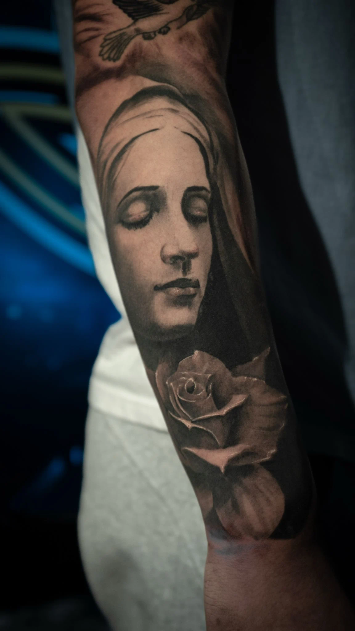 Praying Virgin Mary with rosary forearm tattoo in Tacoma — black and gray by RCD Ink