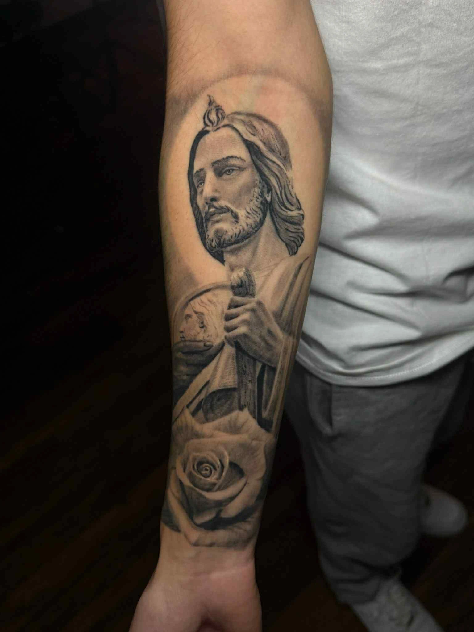 Sacred Heart Jesus forearm tattoo with rose in Tacoma — black and gray by RCD Ink